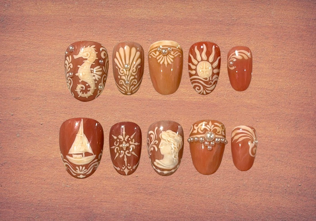 Ten press-on nails with marine themed terracotta and stucco wall frescoes reminiscent of Italian villas on the Mediterranean coast, in rich sienna and warm ivory tones. 