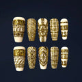 Luxury press-on nail set with intricate gold geometric pattern on an ivory background