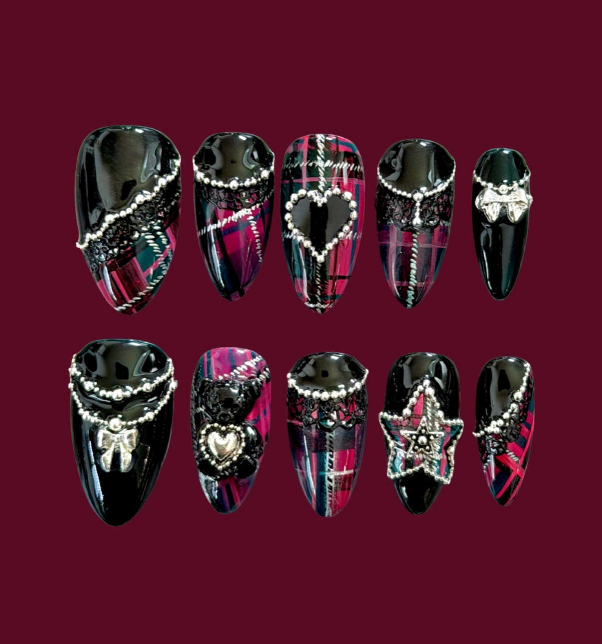 Luxury black and cerise tartan press-on nails with black lace, silver chains, pearls, bows, hearts, and punk-inspired jewelry accents