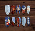 Luxury Western-inspired press-on nails with blue denim texture, paisley patchwork, contrast stitching, silver studs, conchos, and floral accents.
