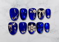 Luxury press-on nails featuring snowflake crystals on Sapphire blue background