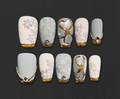 Luxury press-on nails featuring matte translucent floral design with gold and crystal accents